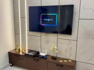 a flat screen tv sitting on top of a cabinet at 3BR Modern Home Fast Wi-Fi & Parking DHA 9 in Lahore