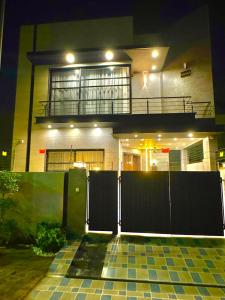 a house with a gate in front of it at night at 3BR Modern Home Fast Wi-Fi & Parking DHA 9 in Lahore