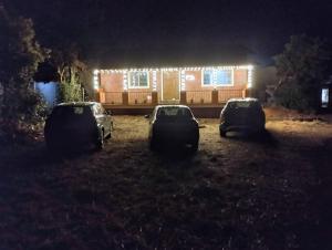 Drei Autos parkten vor einem Haus mit Lichtern in der Unterkunft Deep Homes Umbarkars mahabaleshwar in Mahabaleshwar + 2 Fotos