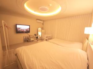 a hotel room with a bed and a flat screen tv at 대전 유천 샌디스테이 