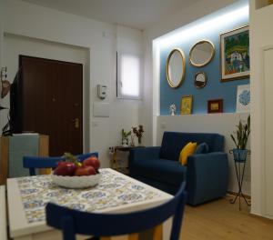 a living room with a table and a blue couch at Nicuzza in Gela