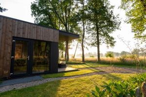 a house with glass doors in a garden at Hofparken Wiltershaar in Winterswijk