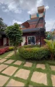 a building with a tree in front of it at Rustic Roots Inn in Jāmb