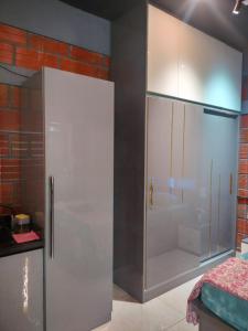 a kitchen with a white refrigerator and a brick wall at Rustic Roots Inn in Jāmb +12 photos