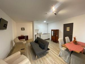 a living room with a couch and a table and a kitchen at Cit'Hotel Primo Colmar Centre in Colmar