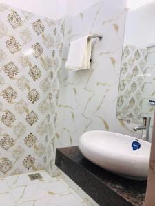 a bathroom with a white sink on a counter at Hayat Grand Guest House in Islamabad