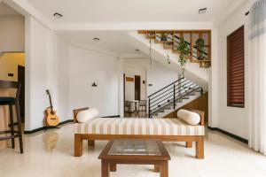 a living room with a couch and a staircase at Sapphire Escape - Private Villa in Ambalangoda in Ambalangoda