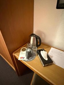 a tea kettle and glasses on a table at Hotel Nassauer Hof Frankfurt in Frankfurt/Main