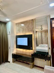 a living room with a flat screen tv on a wall at Hayat Grand Guest House in Islamabad +35 photos