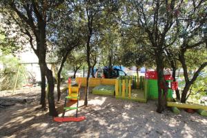 a playground in a park with trees and a swing at Apartments and rooms with parking space Mandre, Pag - 6309 in Kolan