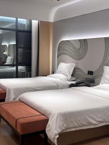 2 bedden in een hotelkamer met 2 bedden van 6 x 7 cm bij Manju Hotel Fuquan People's Square Branch in Fuquan