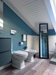 a blue bathroom with a toilet and a mirror at Q suites urban relais in Turin +52 photos