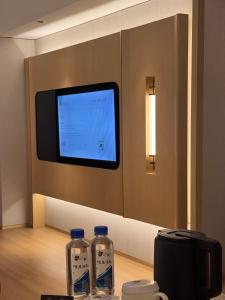 twee flessen water op een tafel voor een tv bij Manju Hotel Fuquan People's Square Branch in Fuquan