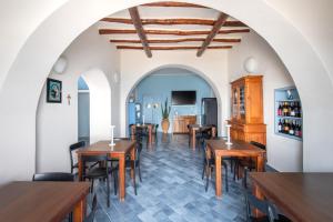a restaurant with wooden tables and chairs in a room at Da Nino sul mare Filicudi in Filicudi