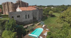 an aerial view of a castle with a swimming pool at Le Logis du Vieux Donjon in Châteaumur
