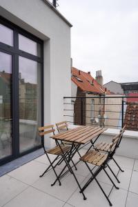 une table en bois et deux chaises sur un balcon dans l'établissement Appartment Veeweyde 5, à Bruxelles