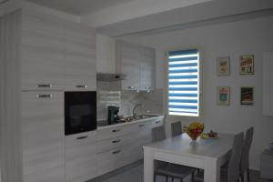 cocina con armarios blancos, mesa blanca y mesa y comedor en Casa Del Portico, en Budrio 7 fotos más