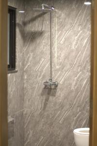 a bathroom with a marble shower with a toilet at Spacious Studio with UPS, across Giga mall, Pool included in Islamabad
