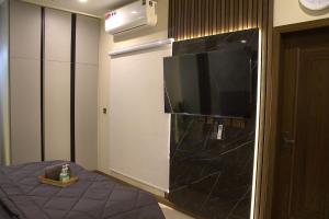 a room with a large television and a bed at Spacious Studio with UPS, across Giga mall, Pool included in Islamabad