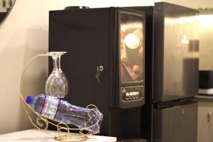 a glass bottle on a table in front of a microwave at Spacious Studio with UPS, across Giga mall, Pool included in Islamabad