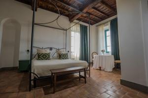 a bedroom with a canopy bed and a table at Casale Malatesta in Velletri