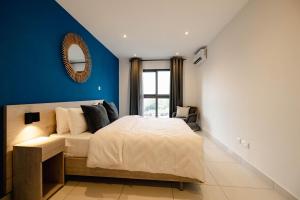 アクラにあるThe Haven-Loxwood Luxury 2-Bed with Rooftop Poolの青い壁のベッドルーム1室(ベッド1台付) +74枚の写真