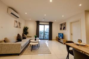 アクラにあるThe Haven-Loxwood Luxury 2-Bed with Rooftop Poolのソファとテーブルのあるリビングルーム