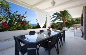 a dining table and chairs on a patio at Villa Mare Panoramica Estia in Brancaleone Marina