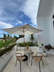 a patio with a table and two chairs and an umbrella at Djeladjah Villa in Ngingas