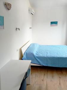 a white room with a bed and a table at Il Borgo in Iglesias