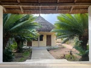 a small yellow building with a thatched roof at The Grove 1-4 bedroom beachfront villa in Cap Skirring