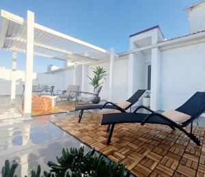 a patio with two chairs on top of a house at Douro Valley Private Terrace & Lounge in Armamar
