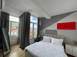 a bedroom with a bed and a large window at I&O Loft360 in Shkodër