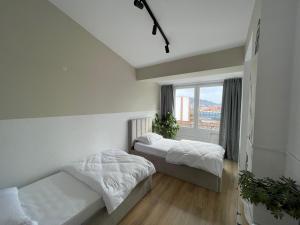 two beds in a room with a window at I&O Loft360 in Shkodër