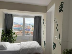 a bedroom with a bed and a large window at I&O Loft360 in Shkodër