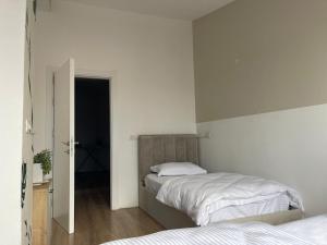 a bedroom with two beds and an open door at I&O Loft360 in Shkodër +3 photos
