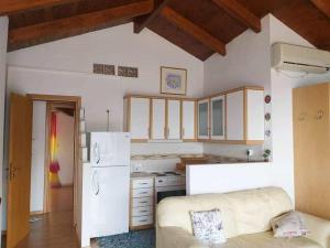 a kitchen with a couch and a white refrigerator at skyview house in Delfoi