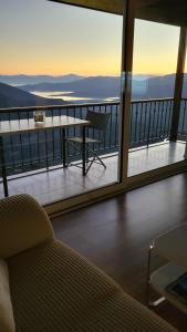a room with a balcony with a table and a couch at skyview house in Delfoi