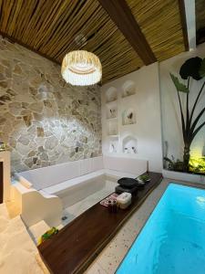 a bathroom with a swimming pool and a bath tub at Djeladjah Villa in Ngingas