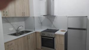 a kitchen with a stove and a sink and a refrigerator at Casa vacanza in Vlorë