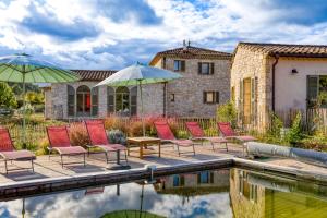 eine Gruppe von Stühlen und Sonnenschirmen neben einem Pool in der Unterkunft Gîte avec piscine de 25 m et spa in Saint-Mathieu-de-Tréviers