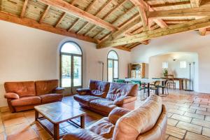 ein Wohnzimmer mit Ledermöbeln und einem Tisch in der Unterkunft Gîte avec piscine de 25 m et spa in Saint-Mathieu-de-Tréviers