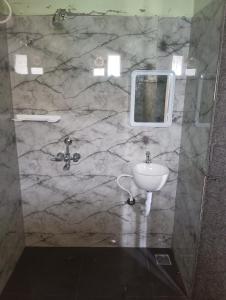 une salle de bain en marbre avec un lavabo et un miroir dans l'établissement Msquare guest house, à Godāvari