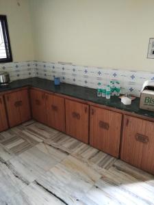 une cuisine avec des armoires en bois et un comptoir dans l'établissement Msquare guest house, à Godāvari