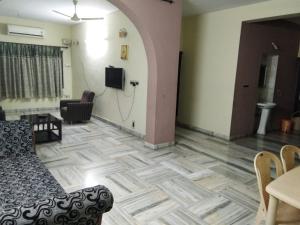 a living room with a couch and a tv on a wall at Msquare guest house in Godāvari