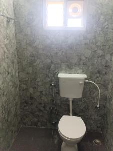 une salle de bain avec des toilettes blanches et une fenêtre dans l'établissement Msquare guest house, à Godāvari