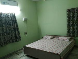 a small bedroom with a bed and a window at Msquare guest house in Godāvari