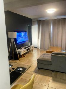a living room with a couch and a flat screen tv at Home away from home in Midrand