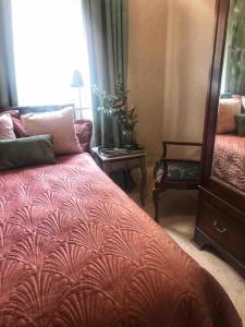 a bedroom with a bed and a table and a mirror at Close to beaches and golf courses in Maybole