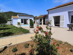 a house with a garden in front of it at Family friendly house with a swimming pool Cunski, Losinj - 24170 in Cunski